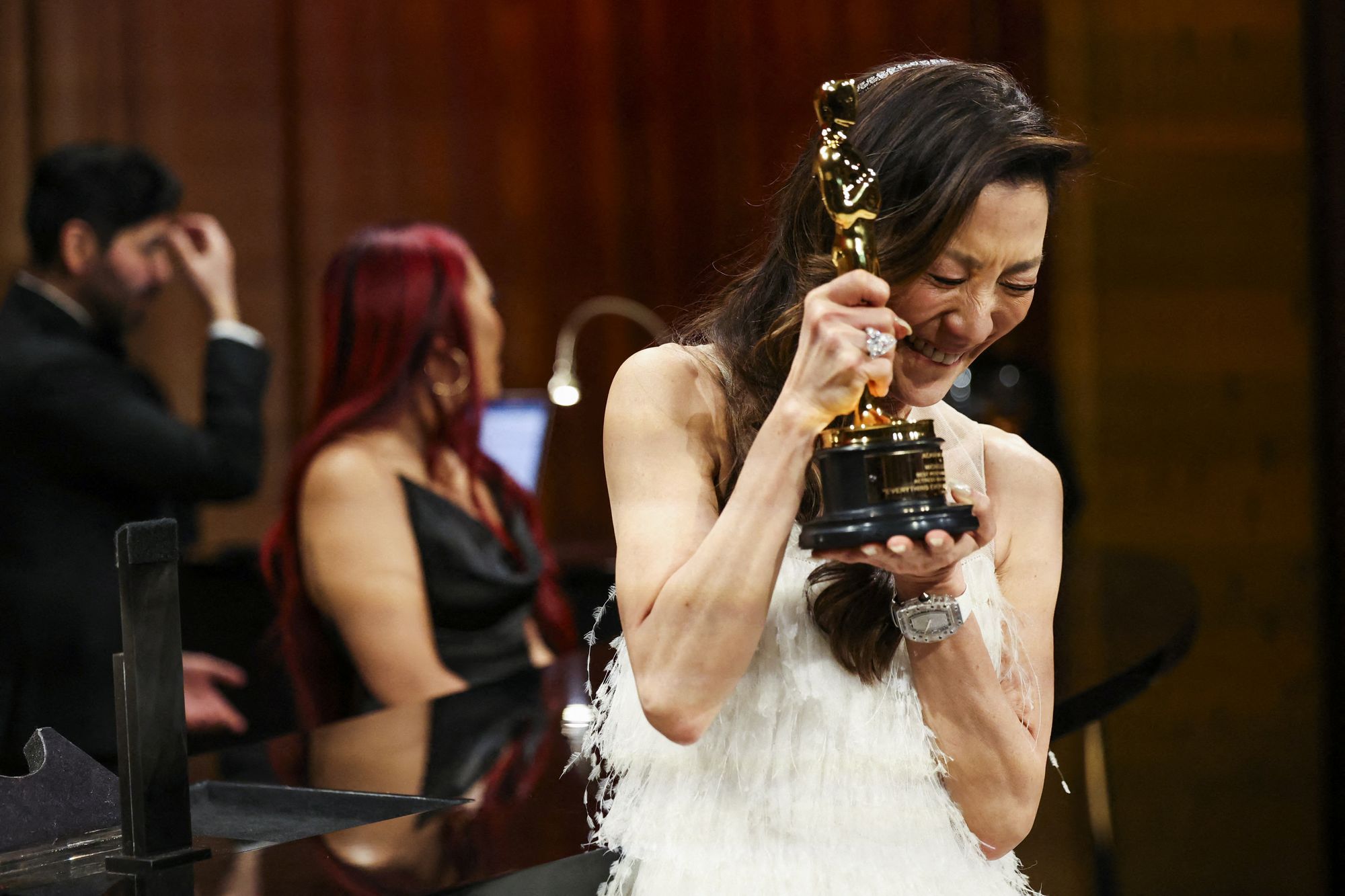 Best actress Michelle Yeoh reacts after having her Oscar engraved