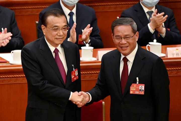 China's former Premier Li Keqiang shakes hands with newly elected Premier Li Qiang