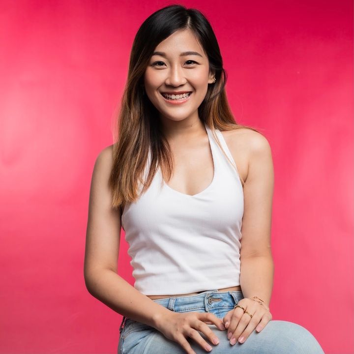 A young woman in Hong Kong with pink background sitting on a chair 