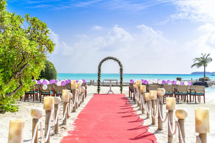 beach wedding setup with red carpet and arch