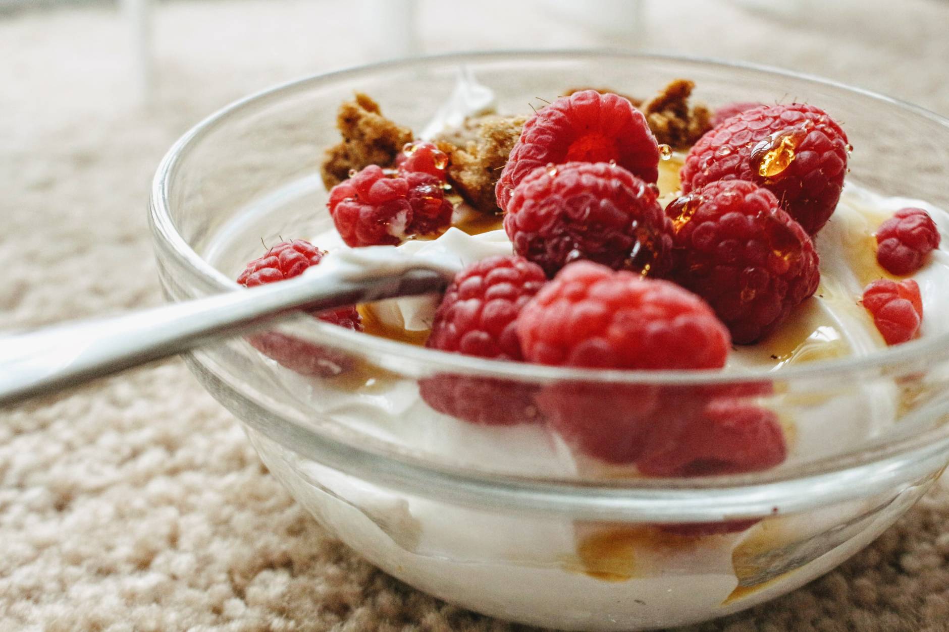 red raspberry on clear glass bowl