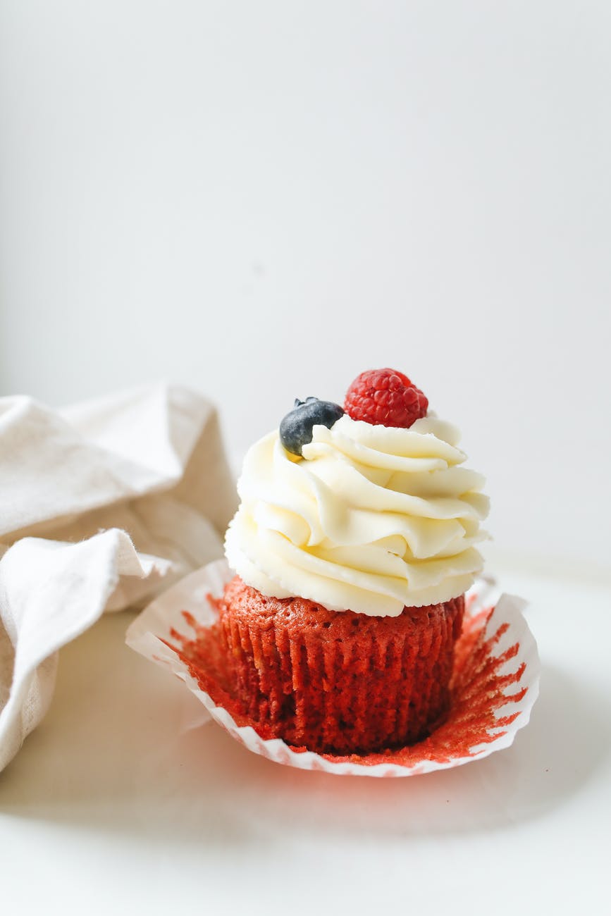 cupcake with icing and berries on top